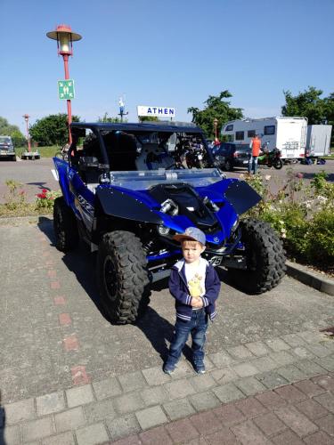 a young boy standing in front of a blue atv at Turmhotel Schwedt in Schwedt