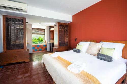 a bedroom with a large bed with a red wall at Tropic Lagoon in Le François