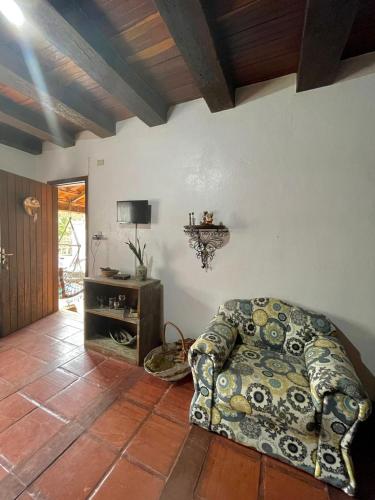 un salon avec un canapé et une télévision dans l'établissement Casa em Ibitipoca - 7 pessoas, à Lima Duarte