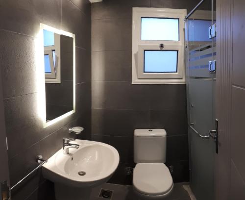 a bathroom with a sink and a toilet and a window at Madinaty 2 in Madīnat ash Shurūq