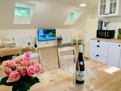 a bottle of wine and flowers on a table in a living room at Apartmány Jetřichovice - České Švýcarsko in Jetřichovice