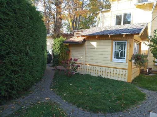 uma pequena casa com uma cerca ao lado de um quintal em Jurmala`s Center Mini House em Jūrmala