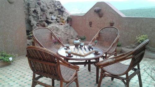 een tafel en vier stoelen met een schaakbord op een patio bij berber house in Taourirt
