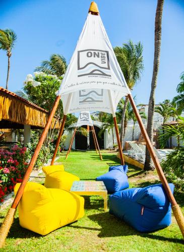 a tent with chairs and a table in the grass at Pousada ON VIBE Cumbuco in Cumbuco