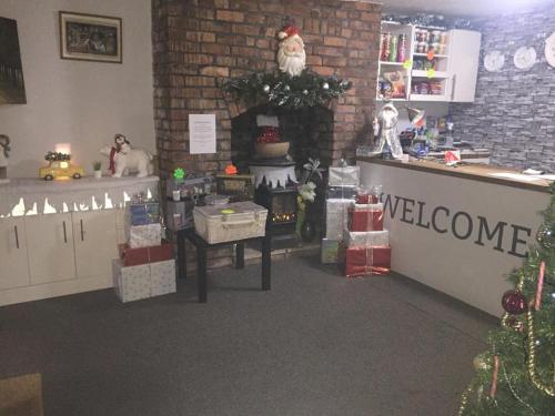 a store with a christmas tree and a welcome sign at Queens Guesthouse Manchester in Manchester