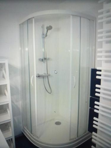 una ducha en una habitación blanca junto a un teclado en Résidence le plaisance, en Pornichet
