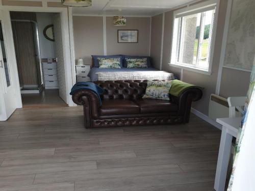 a living room with a couch and a bed at North Muasdale Farm in Muasdale