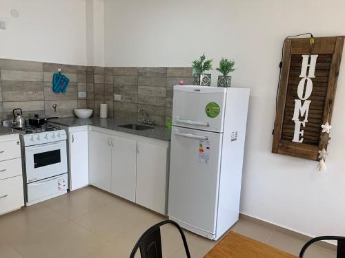 a kitchen with a white refrigerator and a sink at Solar del Río in Concepción del Uruguay