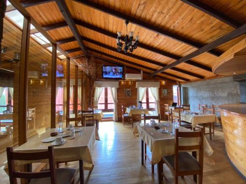 a dining room with tables and chairs and a tv at Hostal Caulle in Río Bueno