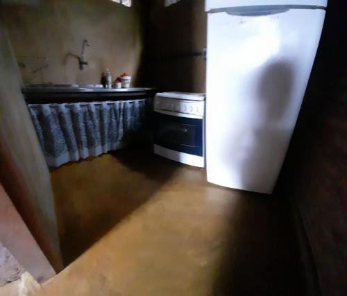 Casa com quintal no centro histórico de Mariana/MG في ماريانا: وجود ثلاجة بيضاء في مطبخ مع حوض