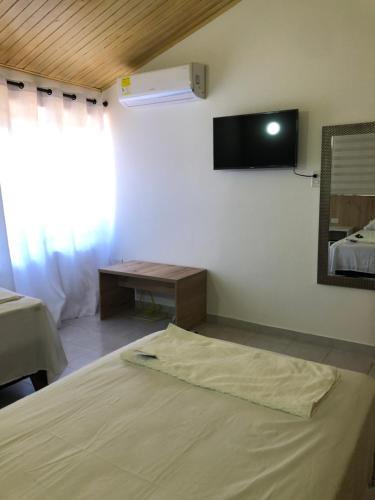 a bedroom with a bed and a television on the wall at Casa LOURDES in Valledupar