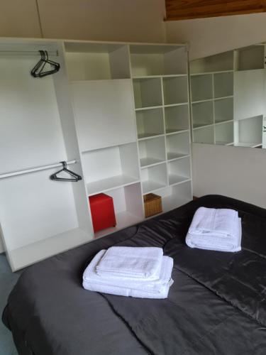 una camera con un letto con due asciugamani di Valle Florido a Trevelin