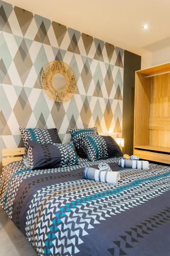 - une chambre avec un grand lit et un mur en damier dans l'établissement La Villetta G Riedisheim - appartement de Standing, à Riedisheim