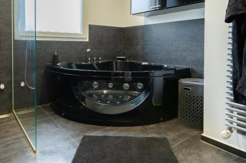 ein Badezimmer mit Badewanne und Waschbecken in der Unterkunft La Villetta G Riedisheim - appartement de Standing in Riedisheim