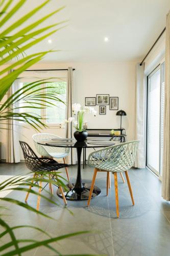 une salle à manger avec une table et deux chaises dans l'établissement La Villetta G Riedisheim - appartement de Standing, à Riedisheim