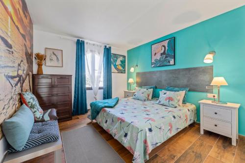 1 dormitorio con cama y pared azul en The Colors House (636) with sea view en Costa Teguise