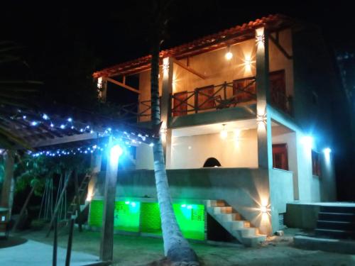 a house with lights in front of it at night at Pousada Recanto Beach in Camocim