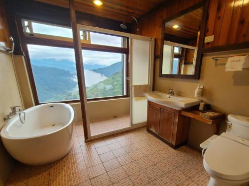 a bathroom with a tub and a toilet and a window at Top Cloud Villa in Renai