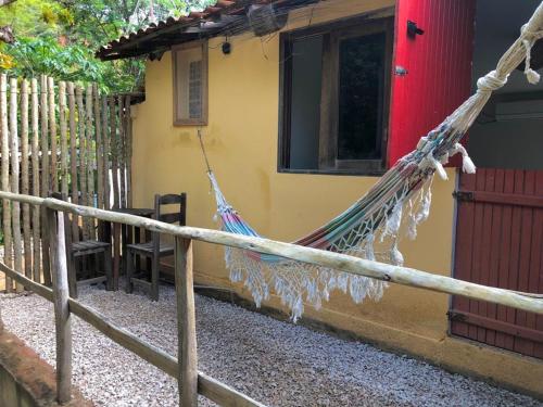 een hangmat aan een hek voor een huis bij Pousada Trilha do Velho Chico in Piranhas