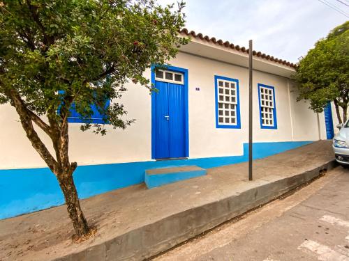 a blue and white house with a blue door at Pousada Doce Villa in Capitólio