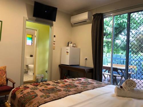 
a hotel room with a bed and a television at Grey Gum Lodge in Nimbin
