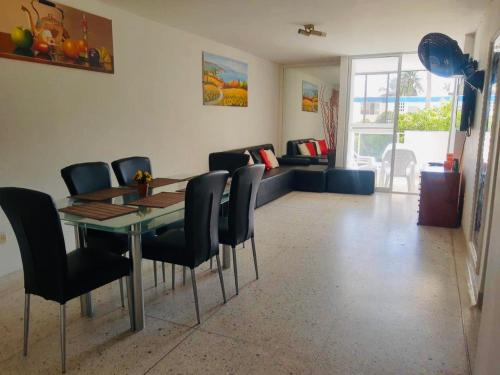ein Esszimmer mit Tisch und Stühlen und einer Couch in der Unterkunft Lindo Apartamento en Rodadero Santa Marta in Santa Marta