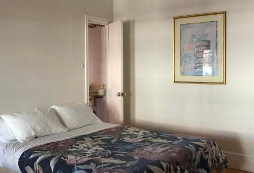 a bed in a room with a picture on the wall at Northlodge Central City Apartments in Perth