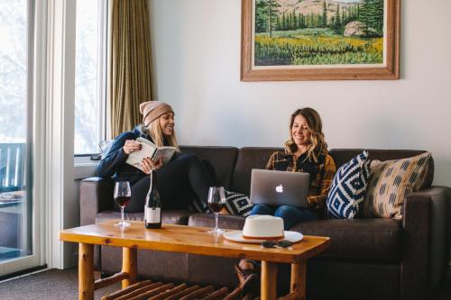 
two women sitting on a couch in front of a laptop computer at Sunnyside Resort and Lodge in Tahoe City
