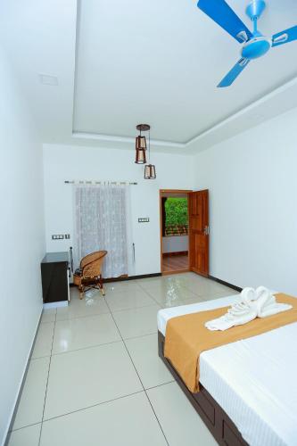 a bedroom with a bed and a ceiling fan at Telma Beach Homestay in Mararikulam