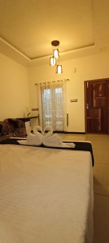 a bedroom with a bed with white sheets and a window at Telma Beach Homestay in Mararikulam