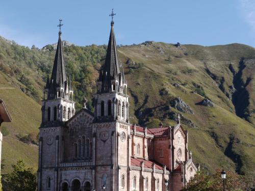 an old church with two towers on a mountain at Hotel Rural El Espino in Cangas de Onís