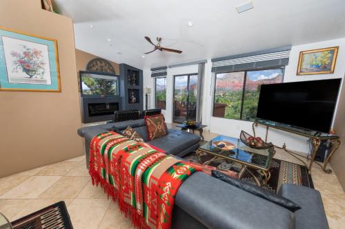a living room with a couch and a flat screen tv at A Sunset Chateau in Sedona