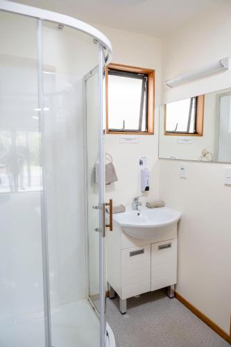 a bathroom with a sink and a shower at ASURE Aspiring Court Motel in Haast