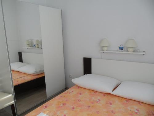Habitación con espejo y cama. en Apartments M&M en Grebaštica