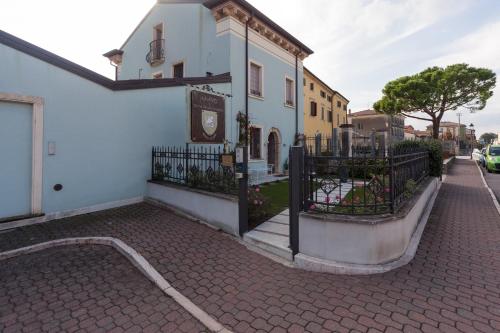 a white building with a gate on a street at Talamo Rooms in San Martino Buon Albergo