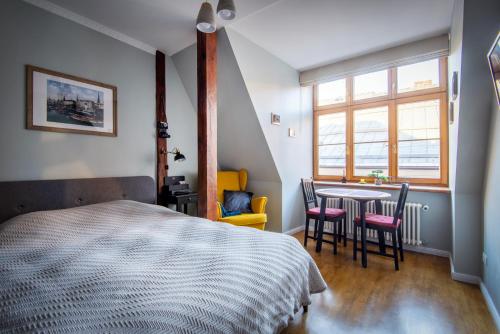 a bedroom with a bed and a table and chairs at Langer House apartment in Old Riga in Rīga