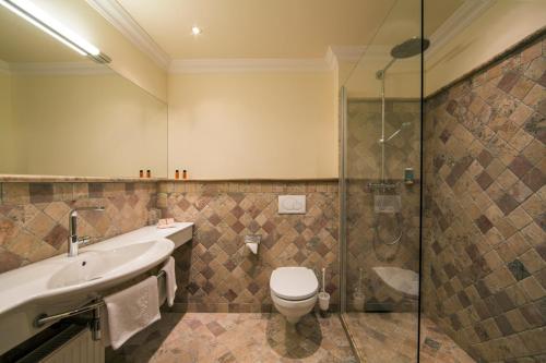 e bagno con servizi igienici, lavandino e doccia. di Hotel Jenbacherhof B&B a Jenbach