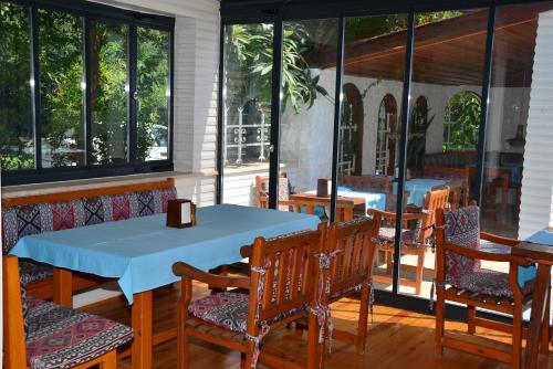 a restaurant with tables and chairs and windows at Aquarius Hotel in Side