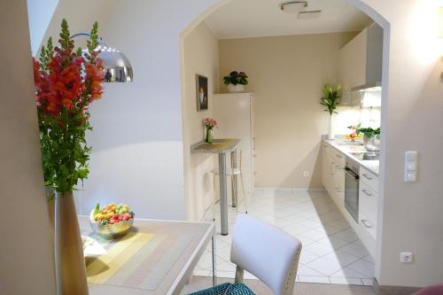 a kitchen with a table, chairs, and a vase of flowers at Hotel an der Oper in Munich