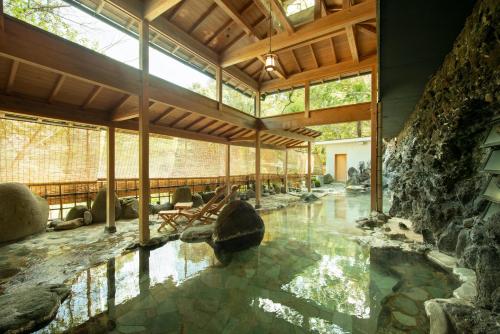 una camera con una piscina d'acqua in un edificio di Ochiairo a Izu