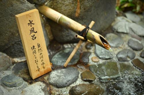 a bamboo stick and a sign on some rocks at Ochiairo in Izu