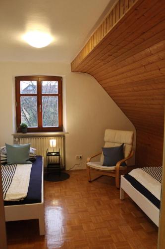 a room with two beds and a chair and a window at Sandsteinhaus mit Garten im Naturpark Hassberge in Kirchlauter