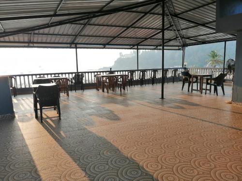 a dining area with tables and chairs on a balcony at Baga Beach Sunset in Baga
