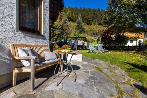 a patio with a bench and a table with fruit on it at Sportpension Bergblick in Wagrain