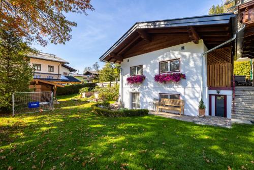 a white house with flowers on the window at Sportpension Bergblick in Wagrain