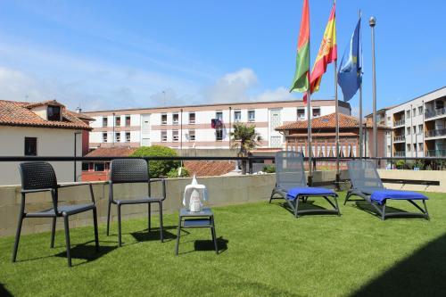 a group of chairs sitting on a lawn with flags at Montemar in Llanes
