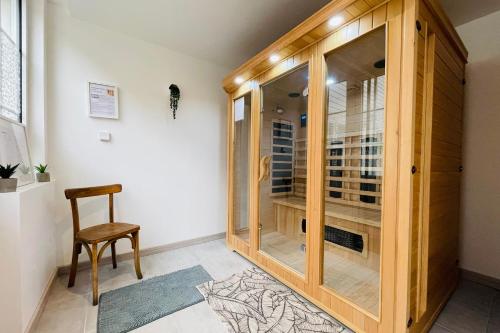 a wooden cabinet in a room with a chair at LE LÉONARD Échappée Amboisienne avec sauna partagé in Amboise