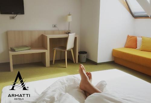 a person laying on a bed in a room at Hotel Armatti in Braşov