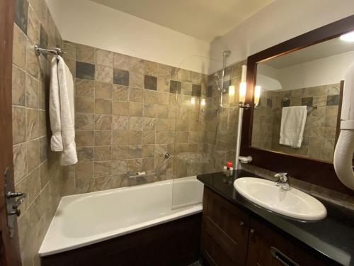 a bathroom with a sink and a bath tub and a sink at Arc 1950 - Appartement Premium Rénové - Manoir Savoie in Arc 1950