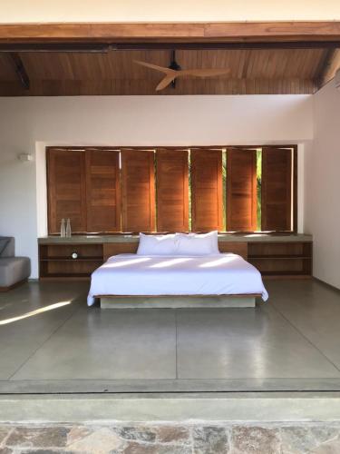 a bedroom with a large white bed and wooden cabinets at Arachchi Heritage in Anuradhapura